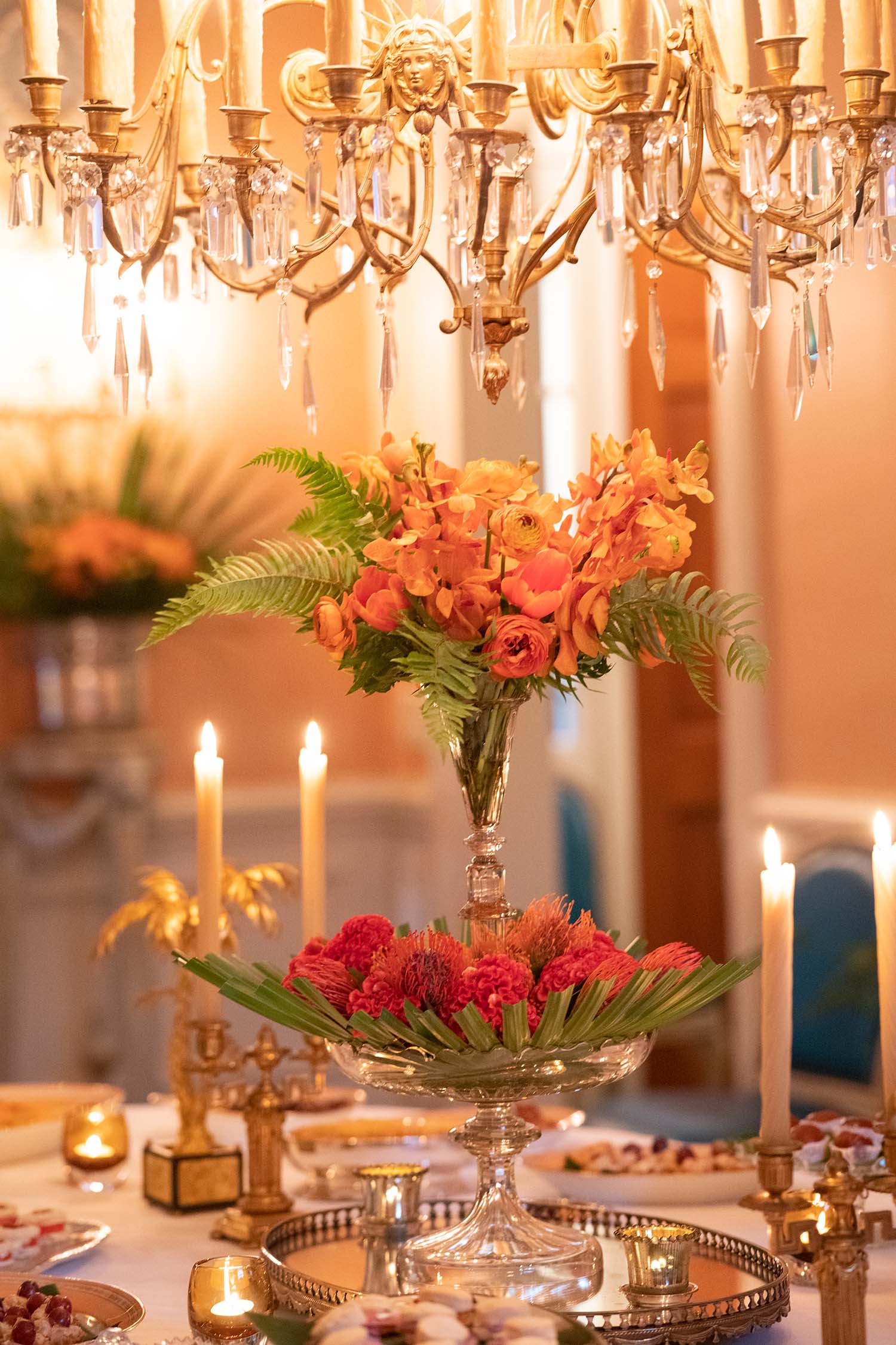 A crystal flute holds tropical flowers on a table.