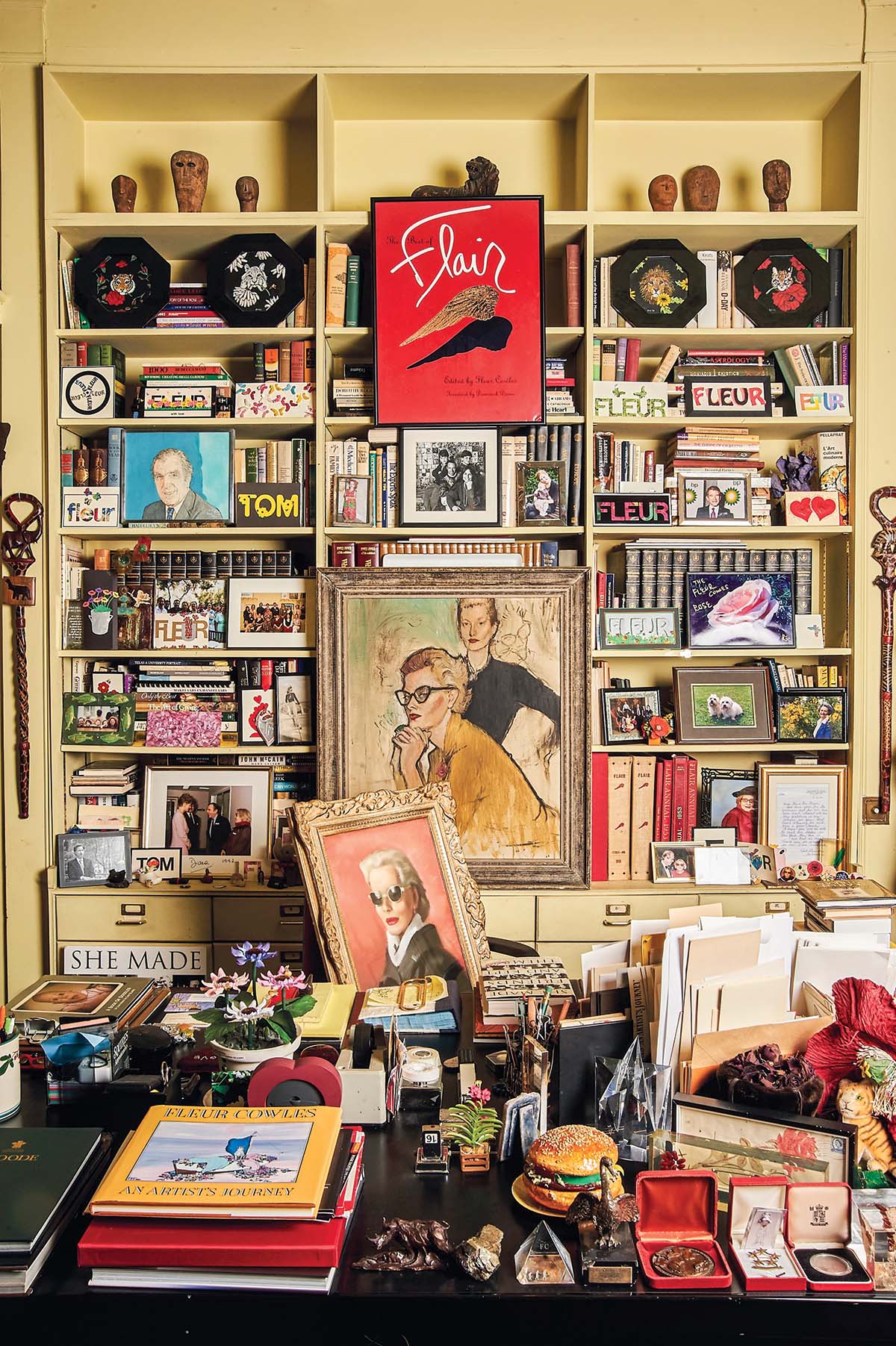 A bookshelf wall filled with records, books and art.