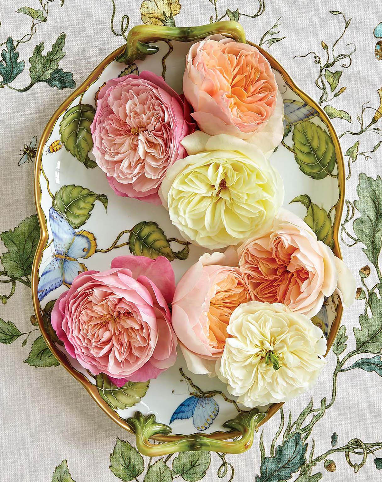 Fluffy pink and orange roses on a floral platter.