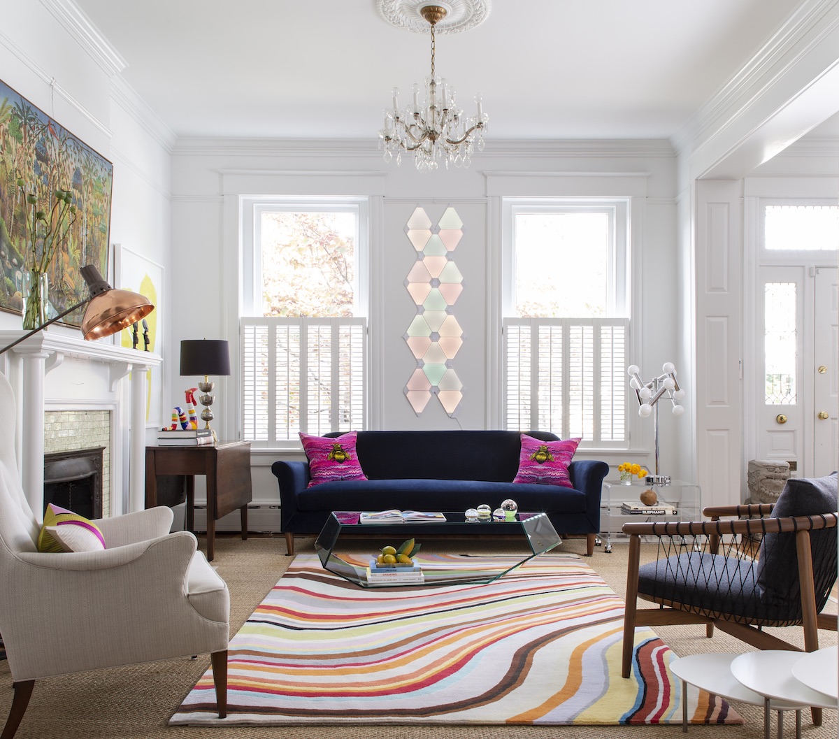 Tollett created a mash up of interesting pieces and colors to shake up a historic home. The custom blue sofa with a bench seat serves as a grounding element in the room.