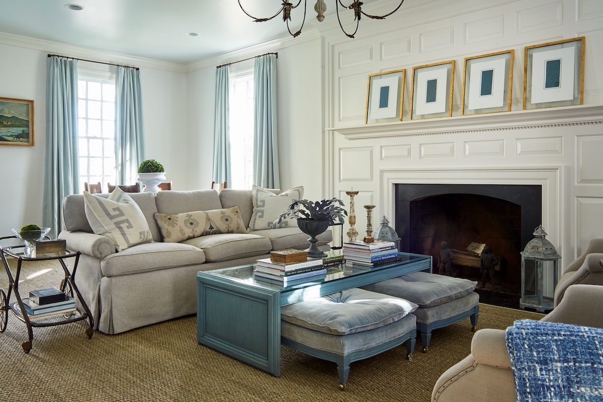 A pair of winged chairs, nesting ottomans, and a vintage Italian tea cart give these homeowners the flexibility to rearrange this space based on their varying entertaining needs.