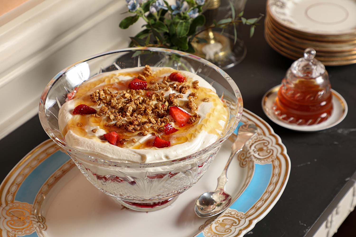 A bowl of creamy cranachan and strawberries sit on a platter.