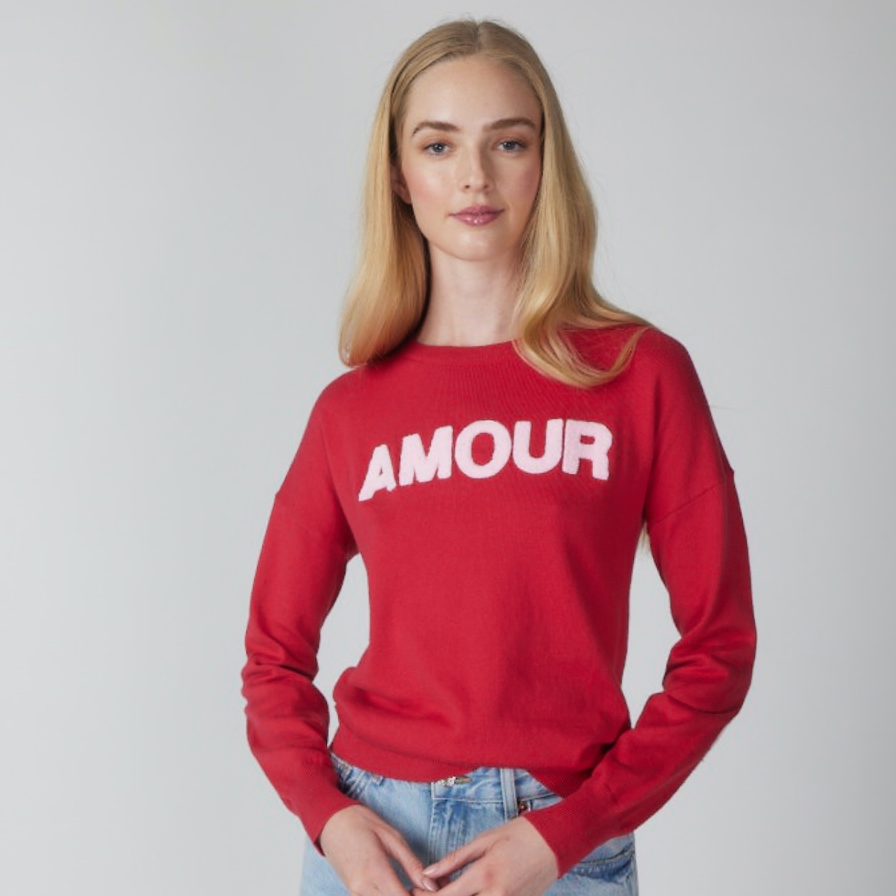 Woman in a red sweater with the word Amour written on it.
