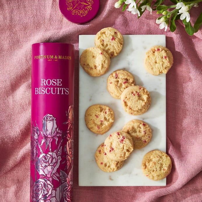 Rose flavored biscuits scattered across a pink tablecloth.