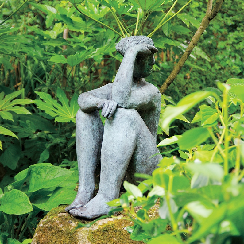 A Saskia Pfaeltzer sculpture sits atop a rock.