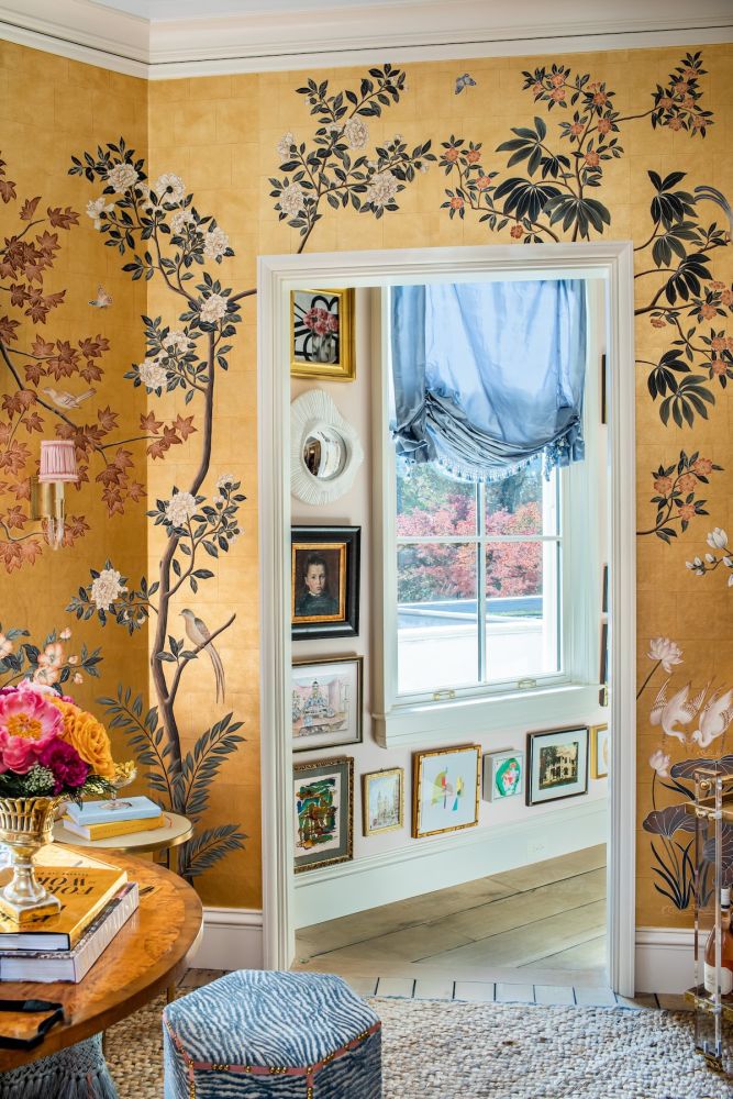 A gallery wall in a hallway off of a gold chinoiserie wrapped suite.
